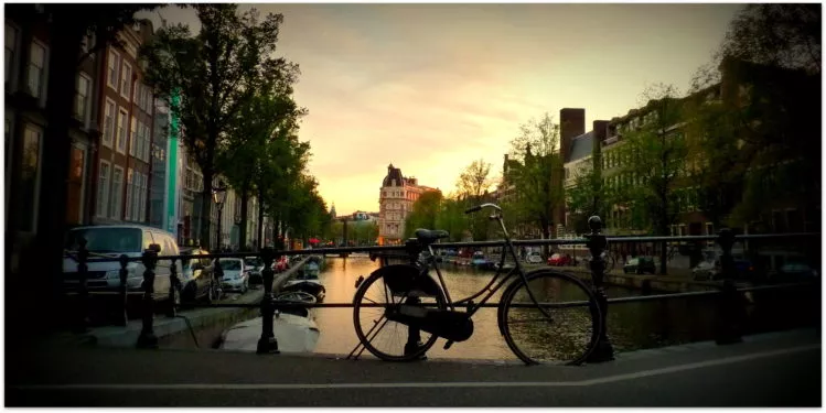 Fahrrad welches an einem Brückengeländer angelehnt wurde in Amsterdam