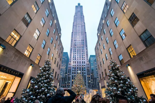 Das Rockefeller Center. Davor einige reich dekorierte Weihnachtsbäume.