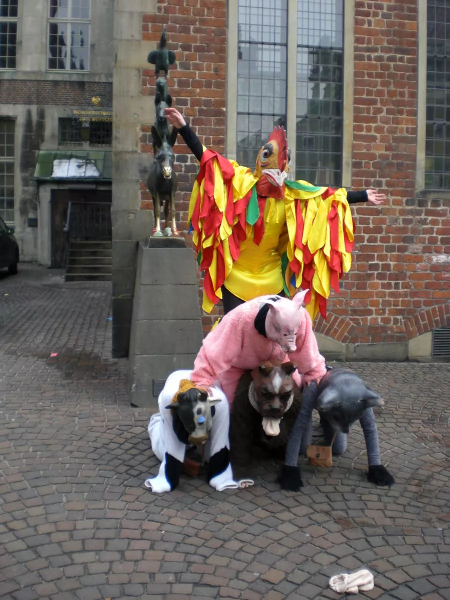 Bremen im März 2013, die Bremer Stadtmusikanten werden von ein paar Jecken in Kostümen nachgestellt. Es soll Glück bringen, wenn man die Hufe des Esels anfasst und sich etwas dabei wünscht.