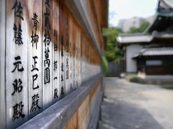 Tafel mit japanischen Schriftzeichen beim Sengakuji Tempel