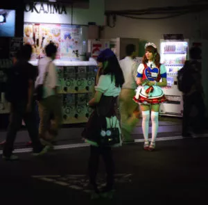 Maid bei Nacht vor Getränkeautomat in Akihabara