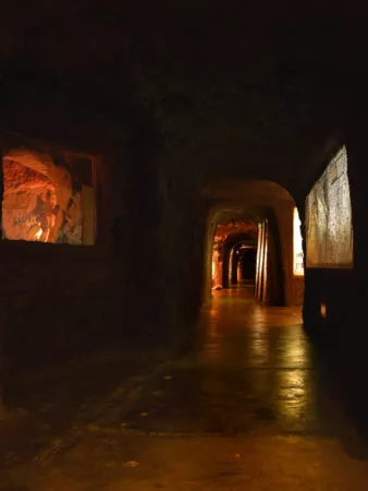 dunkler Tunnel im Museum mit beleuchteten Ausstellungskammern
