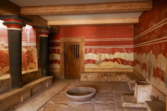 Kleiner Raum mit Steinthron und roten Wandmalereien