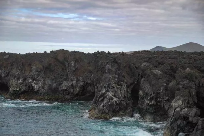 Angler im Felsen an der Los Hervideros Küstenlandschaft auf Lanzarote