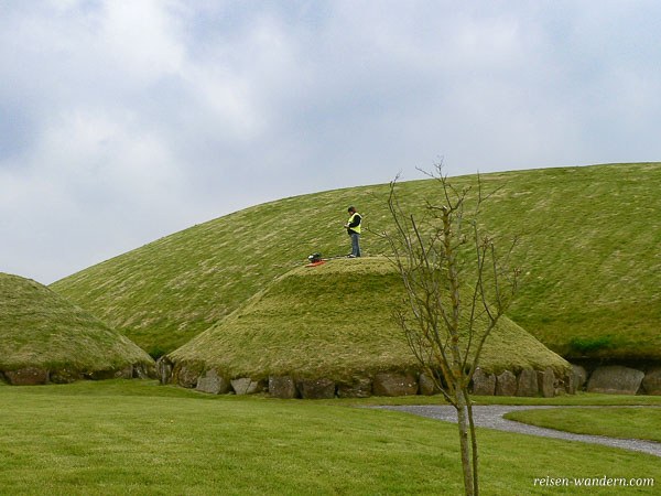 Mann der Rasen mäht auf Hügelgrab in Knowth