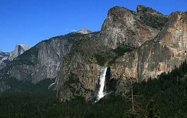 Aus den Bergen stürzt ein Wasserfall in den Wald