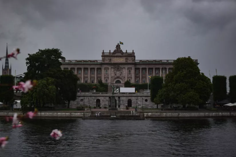 Unter Regenwolken steht das Parlament Stockholms direkt am Wasser