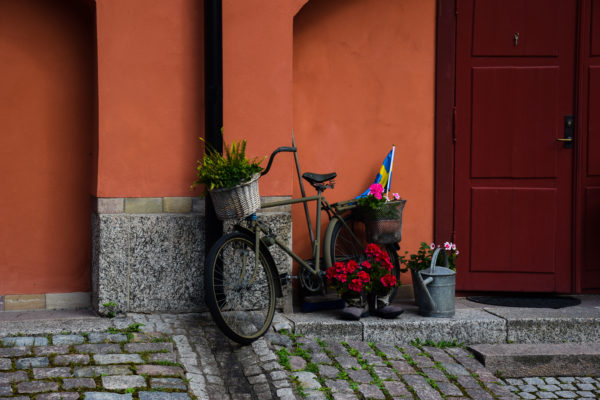 Vor einer orangenen Wand steht ein liebevoll verziertes Fahrrad