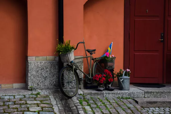 Vor einer orangenen Wand steht ein liebevoll verziertes Fahrrad