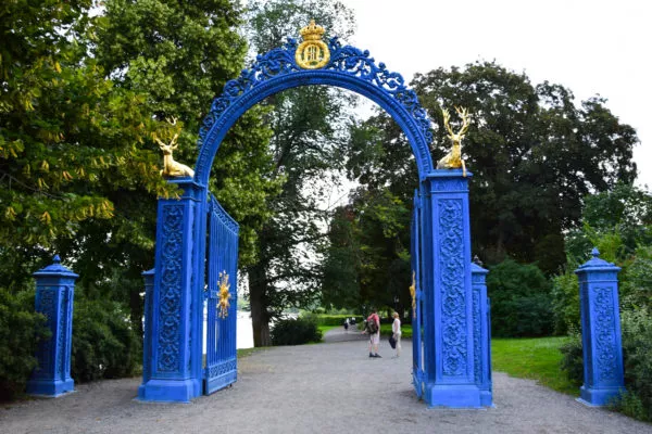 Ein blaues Tor mit goldenen Figuren stellt den Eingang zum Park da