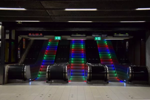 Eine Rolltreppe wird mit bunten Lichtern bestrahlt