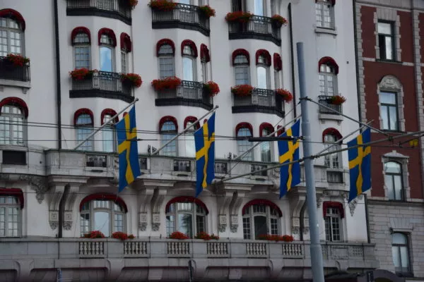 An einer Fassade hängen 4 schwedischee Flaggen