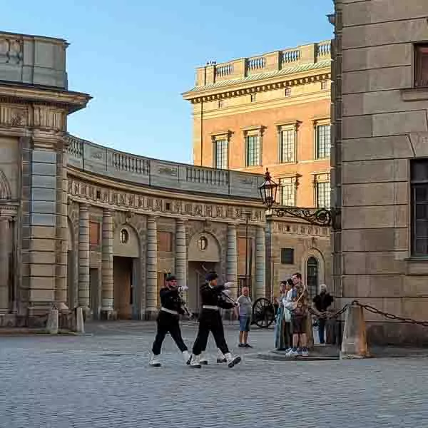 Zwei Wachen laufen über den Platz am Königspalast in Stockholm