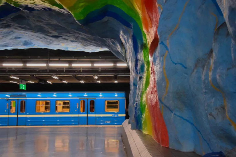 Eine U-Bahn fährt in eine Station ein, welche mit einem Regenbogen gestaltet ist