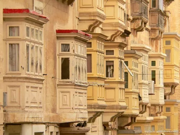 Eine Häuserreihe aus hellem Stein und voller Balkone in Valletta