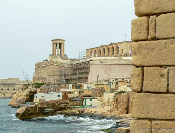 Die Siegesglocke "Siege Bell" in Valletta steht weit oben auf einer steinernen Mauer direkt an der Küste