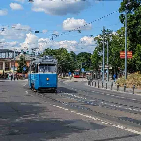 Eine kleine, blaue Straßenbahn fährt durch die Straßen Stockholms