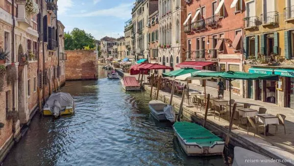 Boote in und Cafes an einem Kanal in Venedig