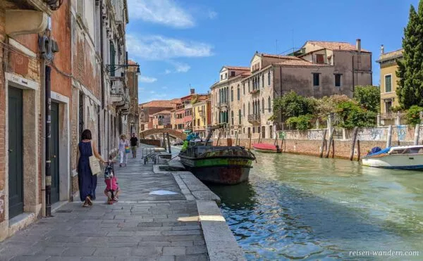 Kanal mit Boot und Frau mit Kind in Venedig