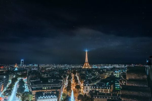 Blick auf das nächtliche Paris mit dem leuchtenden Eiffelturm in der Ferne