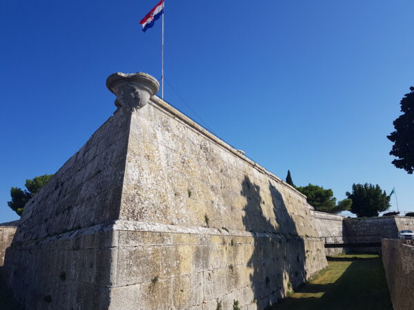 Die Ecker der Festungsmauer Pulas, obenauf eine Flagge Kroatiens