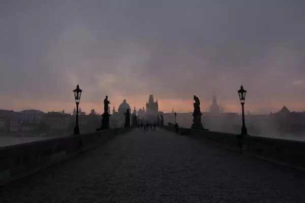 Die Karlsbrücke in Prag liegt bei Sonnenaufgang im Nebel