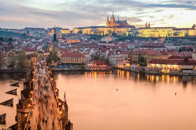Blick vom einen Moldauufer auf die Karlsbrücke und den Burgberg in Prag im Abendlicht