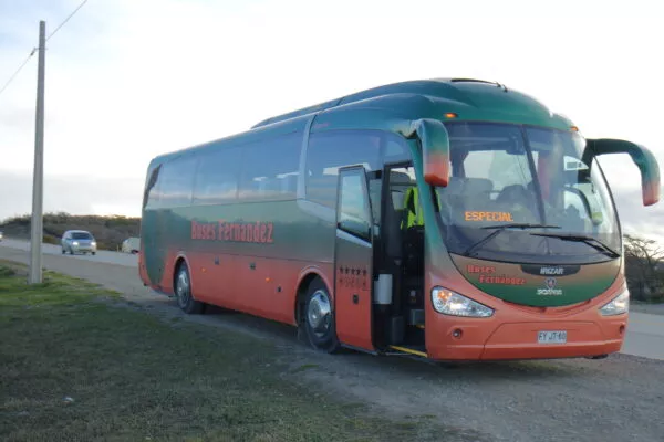 Ein orange-grüner Reisebus auf einer Straße