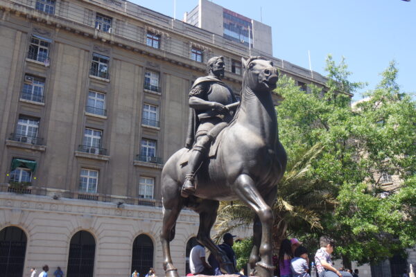 Eine Reiterstatue aus Metall vor einem hohen Gebäude