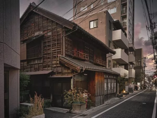 Ein traditionelles japanisches Holzhaus zwischen hohen Betonbauten 