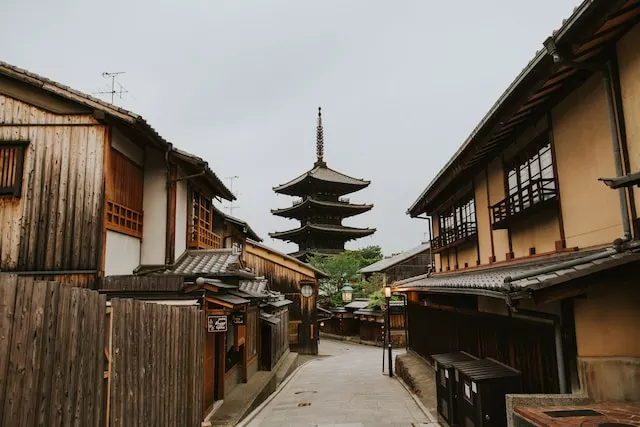Eine Straße, an deren Ende eine Pagode zu erkennen ist. Rechts und links davon sind alte japanische Häuser – Machiya – mit vielen Holzelementen zu sehen