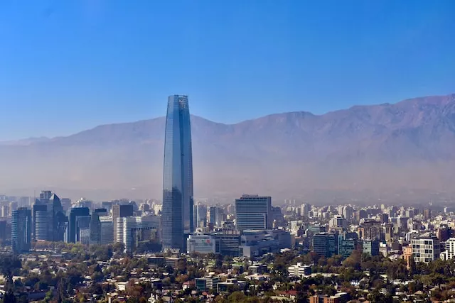 Panaoramablick über Santiago de Chile, die Hauptstadt des längsten Landes der Welt, mit einem einzelnen Wolkenkratzer vor einer Bergkette