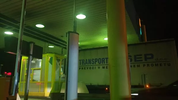 An einem Grenzübergang steht bei Nacht ein LKW an einem der Kontrollhäuschen 