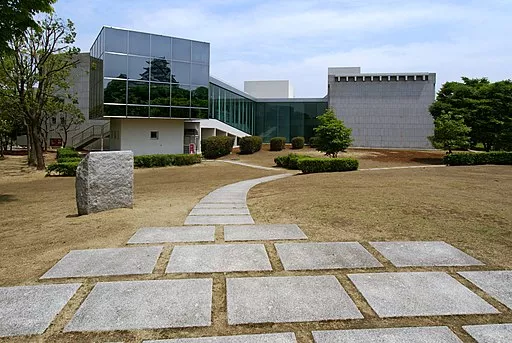Das moderne Gebäude des archäologischen Museums in Himeji, zu dem ein Weg aus großen Pflastersteinen führt 