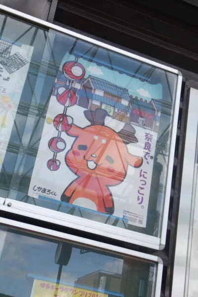 Ein japanisches Plakat mit einem niedlichen Cartoon-Reh hinter einer Glasscheibe