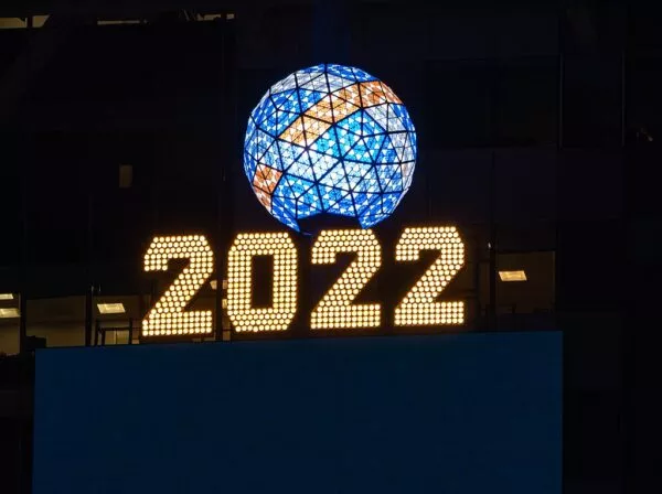 Der blau, gelb und weiß leuchtende Ball am Times Square über der gelb erstrahlenden Jahreszahl 2022