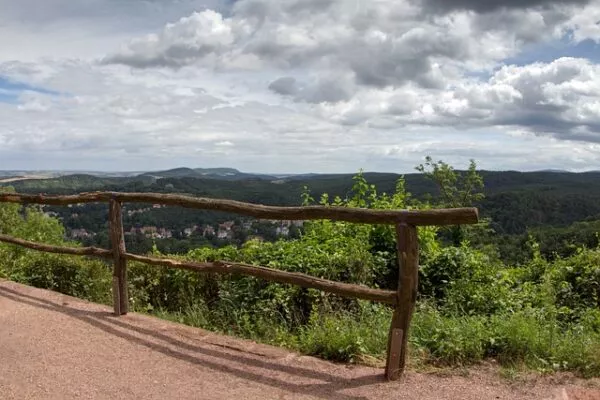Ausblick über ein Tal geschützt durch ein hölzernes Geländer