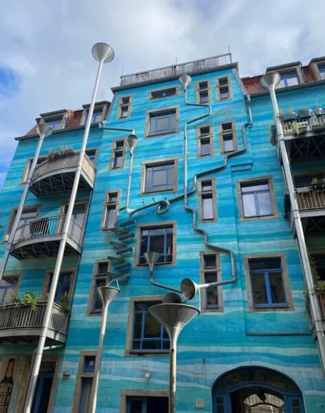 in verschiedenen Blautönen wie Wasser angestrichene Hausfront mit einem Wasserspiel, das sich über die ganze Höhe zieht 